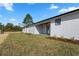 Exterior view of a home with a covered patio and spacious backyard with newly planted landscaping at 31905 Larkspur Ave, Eustis, FL 32736