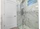 Modern bathroom with a glass-enclosed shower featuring marble-style tile and a multi-setting showerhead at 31905 Larkspur Ave, Eustis, FL 32736