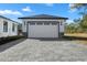 Detached two car garage with a paved driveway and stone accents, matching the main house at 31905 Larkspur Ave, Eustis, FL 32736