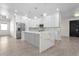 Open-concept kitchen with white cabinets, gray island, stainless steel appliances, and stone backsplash at 31905 Larkspur Ave, Eustis, FL 32736