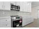 Modern kitchen features stainless steel appliances and sleek white cabinetry with stylish hardware at 31905 Larkspur Ave, Eustis, FL 32736
