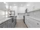 Bright kitchen featuring stainless steel appliances, white cabinets, mosaic backsplash, and gray island at 31905 Larkspur Ave, Eustis, FL 32736
