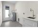 Functional laundry room with white cabinets, utility sink, and water heater, offering convenience and efficiency at 31905 Larkspur Ave, Eustis, FL 32736