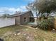 Private backyard with a covered patio, white fence, and mature trees at 332 Lake Doe Blvd, Apopka, FL 32703