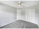 Bedroom with neutral walls, gray carpeting, ceiling fan, and closet doors at 332 Lake Doe Blvd, Apopka, FL 32703