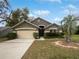 Charming single-story home featuring a well-maintained lawn, mature trees, and an attached two-car garage at 332 Lake Doe Blvd, Apopka, FL 32703