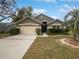 Charming single-story home featuring a well-maintained lawn, mature trees, and an attached two-car garage at 332 Lake Doe Blvd, Apopka, FL 32703