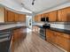 Well-lit kitchen with stainless steel appliances, wood cabinets, and tiled backsplash at 332 Lake Doe Blvd, Apopka, FL 32703