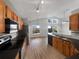 Well-lit kitchen featuring wood cabinets, stainless steel appliances, and a black countertop at 332 Lake Doe Blvd, Apopka, FL 32703