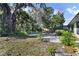 Backyard features mature trees, greenery and a brick path leading to a wooden deck at 342 Oak Estates Dr, Orlando, FL 32806