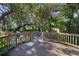 Wooden deck with railing overlooking a lush backyard with mature trees and landscaped pathway at 342 Oak Estates Dr, Orlando, FL 32806