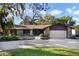 Charming single-story home with stone accents, mature landscaping, and an attached two-car garage at 342 Oak Estates Dr, Orlando, FL 32806