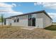 Exterior view of the home's backyard featuring a sliding glass door and grass at 3876 Giorgio Dr, Winter Haven, FL 33884