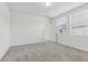 Bright bedroom with two windows, neutral carpet, and a door that leads to an adjoining room at 3876 Giorgio Dr, Winter Haven, FL 33884