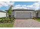 Exterior view of a one-story home with a two-car garage, brick driveway, and landscaping at 3876 Giorgio Dr, Winter Haven, FL 33884