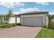 Exterior view of a one-story home with a two-car garage and landscaped front yard at 3876 Giorgio Dr, Winter Haven, FL 33884
