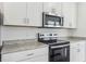 Updated kitchen featuring granite countertops, stainless steel microwave, and stove at 3876 Giorgio Dr, Winter Haven, FL 33884