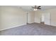 A simple bedroom featuring carpeted flooring, ceiling fan and access to multiple rooms throughout the home at 39 Hickory Course Way, Ocala, FL 34472