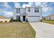 Charming two-story home with a well-manicured lawn, attached garage, and inviting entrance at 39 Hickory Course Way, Ocala, FL 34472