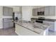 Modern kitchen island with granite countertops, stainless steel appliances, and gray cabinetry at 39 Hickory Course Way, Ocala, FL 34472