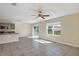 Open-concept living area features tile flooring, ceiling fan, and sliding glass doors to the outdoor space at 39 Hickory Course Way, Ocala, FL 34472
