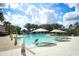 Relax by this sparkling community pool with lounge chairs and umbrellas, surrounded by lush palm trees and clear skies at 394 Captiva Dr, Davenport, FL 33896