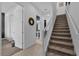 Inviting hallway with staircase, neutral tones, and access to a powder room at 394 Captiva Dr, Davenport, FL 33896