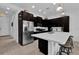 Well-equipped kitchen with an island, dark cabinetry, and stainless steel appliances at 394 Captiva Dr, Davenport, FL 33896