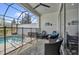Relaxing screened patio featuring comfortable wicker furniture and a partial view of the pool area at 394 Captiva Dr, Davenport, FL 33896