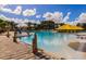 Resort-style pool with shallow water entry, lounge chairs, sun umbrella and brick paver decking, set against lush landscaping at 394 Captiva Dr, Davenport, FL 33896