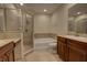 Well-lit bathroom features glass shower, tub and wood cabinets at 4624 Messina Dr, Lake Mary, FL 32746