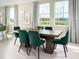 Bright dining room with large windows, a wooden dining table and six green velvet chairs at 4969 Kaia Ave, Winter Haven, FL 33884