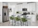 Modern kitchen features white cabinets, stainless steel appliances, and a center island with seating for three at 4969 Kaia Ave, Winter Haven, FL 33884