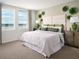 Serene main bedroom with a plush bed, decorative wall art, side tables, and large windows at 4969 Kaia Ave, Winter Haven, FL 33884
