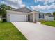 Beautifully maintained home with a spacious driveway, attached garage, and lovely landscaping at 601 Dominish Estates Dr, Apopka, FL 32712