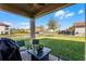 View of outdoor covered patio with brick base, patio furniture, and manicured lawn and landscape at 612 Via Isabelle Dr, Debary, FL 32713