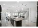 Open kitchen with granite island, modern lighting, stainless appliances, and tile flooring at 612 Via Isabelle Dr, Debary, FL 32713