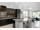Stylish kitchen with dark cabinets, granite counters, stainless steel appliances, and modern light fixtures at 612 Via Isabelle Dr, Debary, FL 32713
