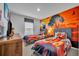 The Lion King themed bedroom featuring two twin beds, sunset wall art, and wooden dresser at 638 Ogelthorpe Dr, Davenport, FL 33897
