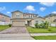 Two-story home featuring a brick driveway, a two-car garage and manicured landscaping at 638 Ogelthorpe Dr, Davenport, FL 33897