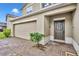 Charming front exterior with a two-car garage and a well-maintained, light-colored brick driveway and walkway at 638 Ogelthorpe Dr, Davenport, FL 33897