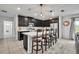 Stylish kitchen featuring a large island with bar stools, dark cabinets, and stainless steel appliances at 638 Ogelthorpe Dr, Davenport, FL 33897