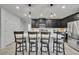 Modern kitchen with stainless steel appliances, dark cabinetry, and a bright white countertop island with seating at 638 Ogelthorpe Dr, Davenport, FL 33897