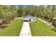 An aerial view of the house and its extensive lush green lawn with treeline on the periphery at 7007 Sw 131St Ave, Ocala, FL 34481