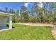 Spacious backyard featuring lush green grass, a treeline, and a covered patio area with room for entertaining at 7007 Sw 131St Ave, Ocala, FL 34481