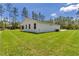 Exterior shot of a home featuring a covered patio, lush lawn, and a view of surrounding trees at 7007 Sw 131St Ave, Ocala, FL 34481