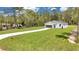 Charming single-story house featuring board and batten siding, a green lawn, and a concrete driveway at 7007 Sw 131St Ave, Ocala, FL 34481