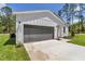 Close-up of an attached garage, featuring a newly landscaped yard and green grass at 7007 Sw 131St Ave, Ocala, FL 34481