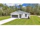 A cozy single-story house with board and batten siding and a dark gray garage door at 7007 Sw 131St Ave, Ocala, FL 34481