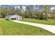Exterior view of the home with lush lawn, long driveway, and an attached garage with a gray door at 7007 Sw 131St Ave, Ocala, FL 34481
